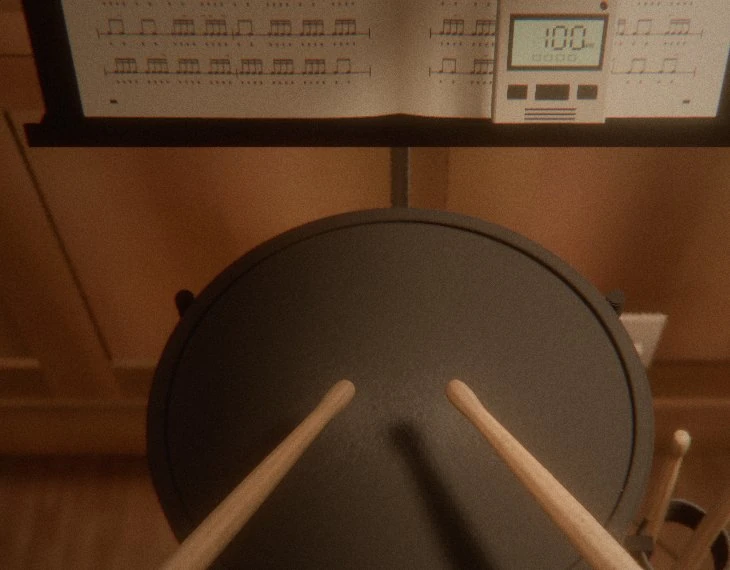 Looking down at the practice pad with two drumsticks resting on it, a music stand with an exercise book and a digital metronome set to 100 behind it, and spare sticks in a bag on the right